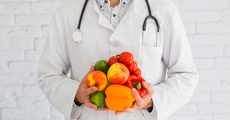 We're Hiring Log in Register Close-up of male doctor's hand holding fresh produce healthy fruit and vegetable