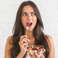 young-woman-eating-fruit-salad-with-fork-DIY-BODY-Diet-Tips